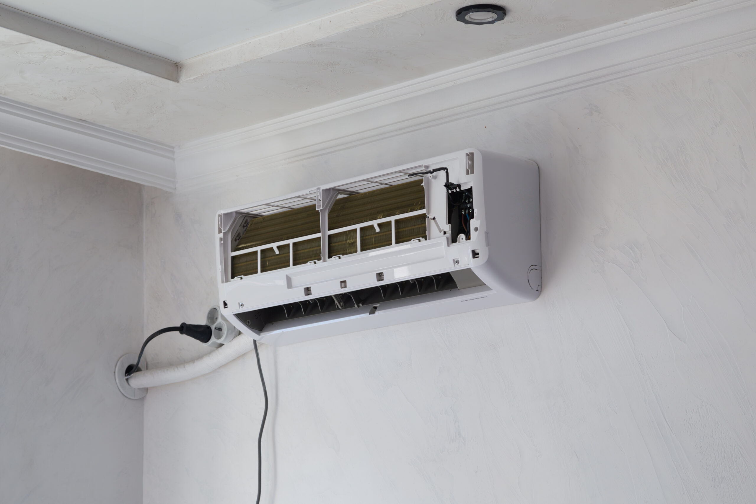 Wall-mounted air conditioner opened for repair and filter cleaning